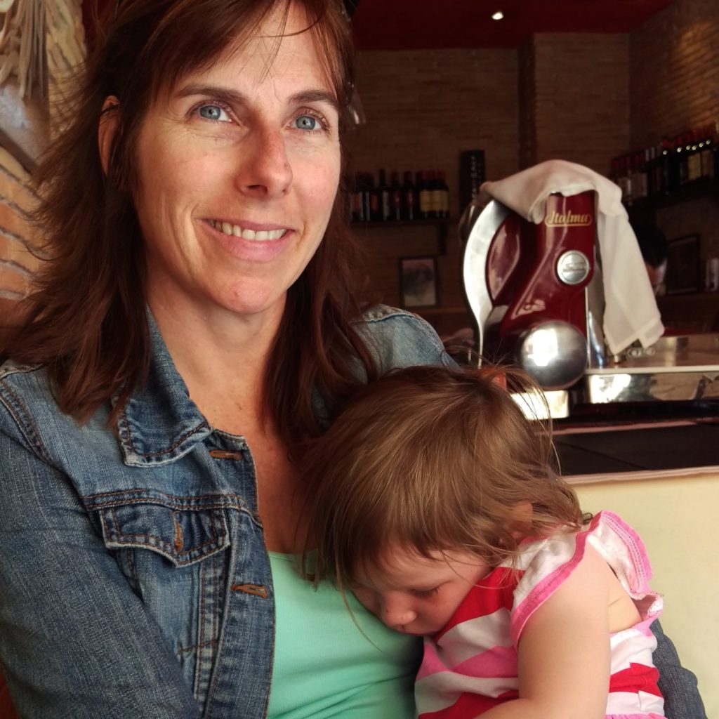 Photo of Laurie Kerr with her daughter, age 2, sleeping on her at a restuarant in Palma, Mallorca, Spain.