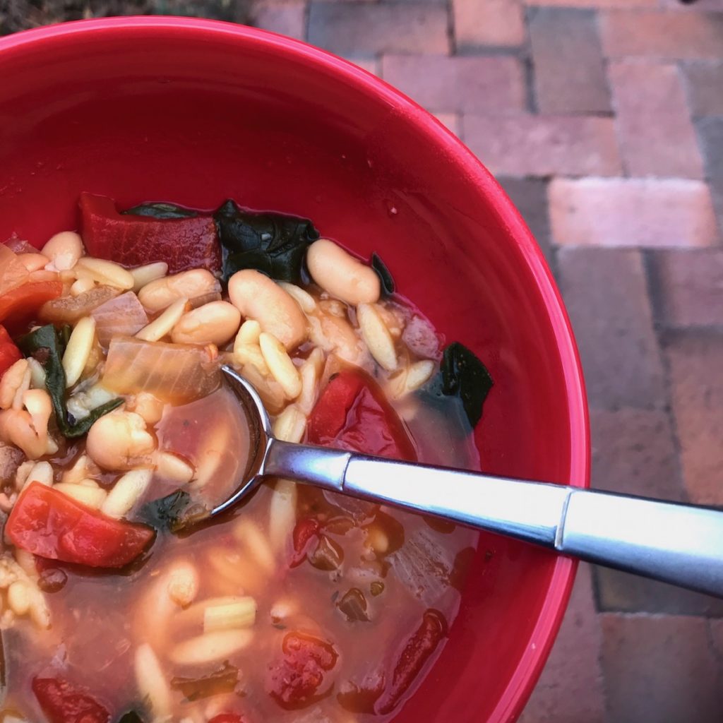 Soup in a red bowl with spoon.